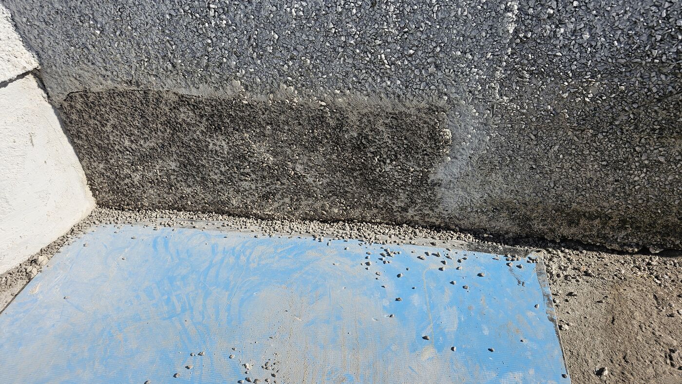 Corner aggregate coat — repair blended into surrounding wall